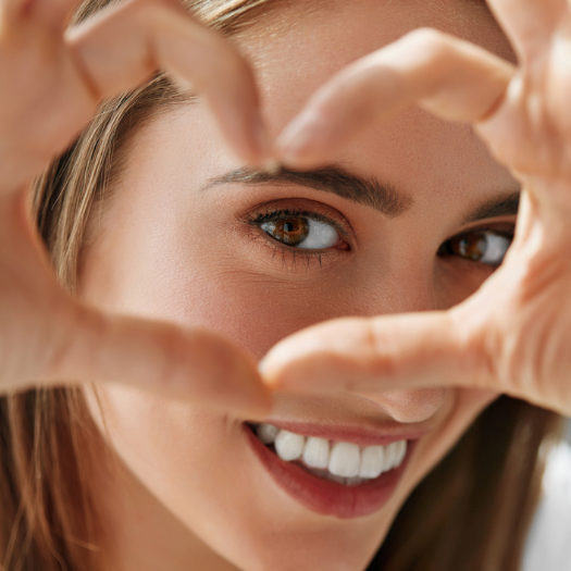 Woman smiling, holding Eye Love products